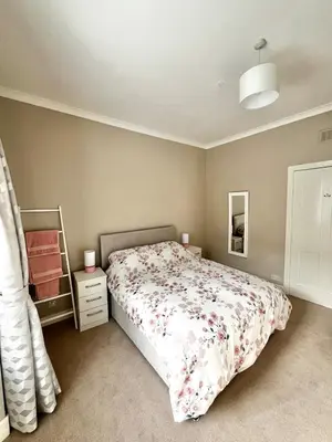 a bedroom with a bed and a mirror at Two Bedroom Apartment in Bridge of Allan in Bridge of Allan
