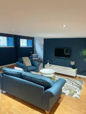 a living room with two blue couches and a tv at SEC Hydro Duplex in Finnieston in Glasgow