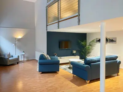 a living room with two blue couches and a couch at SEC Hydro Duplex in Finnieston in Glasgow