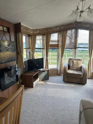 a living room with a television and a chair at Aspen Scenic 53 in Ardentinny