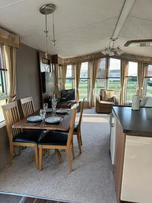 a dining room and living room with a table and chairs at Aspen Scenic 53 in Ardentinny