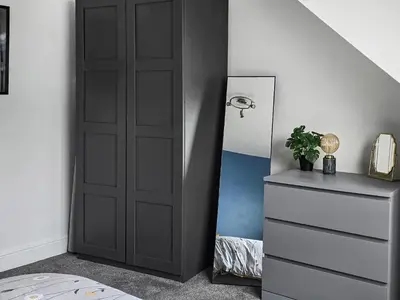 a bedroom with a black door next to a dresser at Holy Loch View in Strone