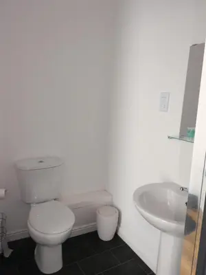 a white bathroom with a toilet and a sink at No 1 - 2 bedroom apartment in Lanark Town Centre in Lanark