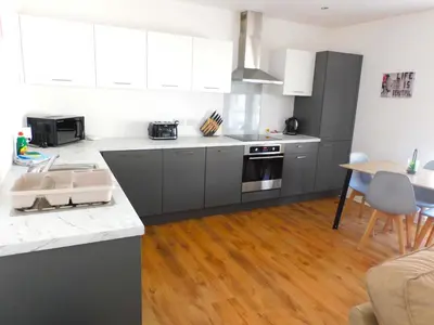 a kitchen with gray cabinets and a wooden floor at No 5 - Modern 2 bedroom Apartment in Lanark Town Centre in Lanark