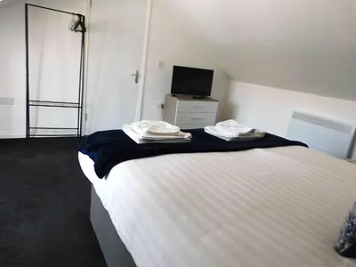 a bedroom with a large bed with towels on it at No 7 - Modern 1 Bedroom Apartment in Lanark Town Centre in Lanark
