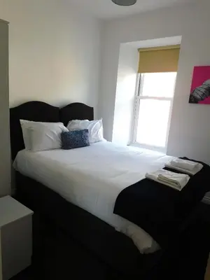 a bedroom with a large white bed with a window at No 9 - Modern 3 Bedroom Apartment in Lanark Town Centre in Lanark
