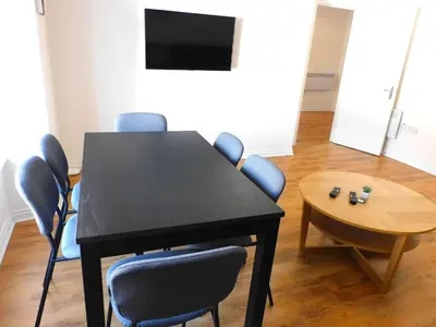 a dining room with a table and chairs and a television at No 9 - Modern 3 Bedroom Apartment in Lanark Town Centre in Lanark