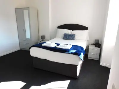 a bedroom with a bed with two towels on it at No 9 - Modern 3 Bedroom Apartment in Lanark Town Centre in Lanark