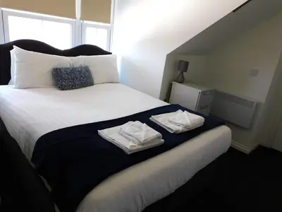 a bedroom with a bed with two towels on it at No 11 - Contemporary 2 Bedroom Apartment in Lanark Town Centre in Lanark