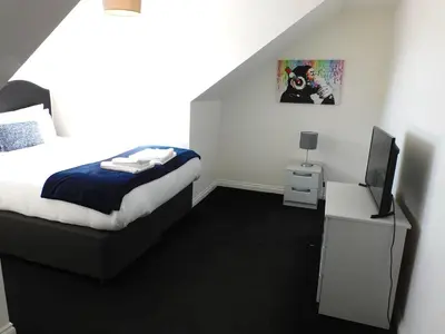a bedroom with a bed and a flat screen tv at No 11 - Contemporary 2 Bedroom Apartment in Lanark Town Centre in Lanark