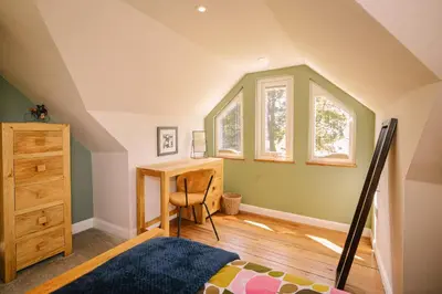 an attic bedroom with a desk and window at Stunning Barn Conversion in Dunlop