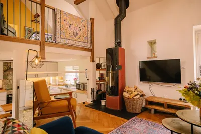 a living room with a fireplace and a flat screen tv at Stunning Barn Conversion in Dunlop