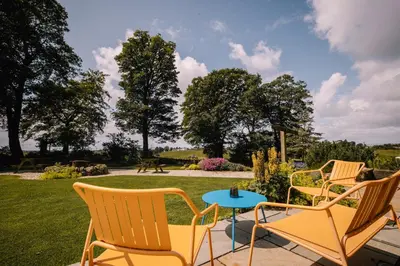 a group of chairs and a table on a patio at Stunning Barn Conversion in Dunlop