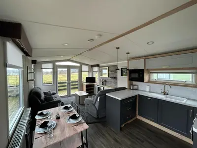 a kitchen and living room with a table in a house at Swift Bordeaux Sea View 10 in Ardentinny