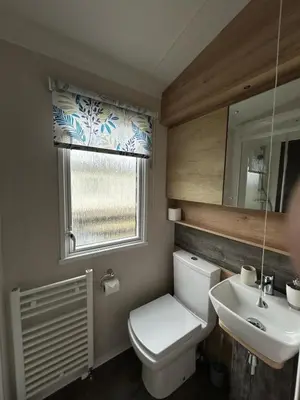 a bathroom with a toilet and a sink and a window at Swift Bordeaux Sea View 10 in Ardentinny