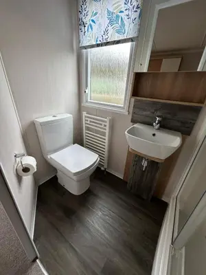a small bathroom with a toilet and a sink at Swift Bordeaux Sea View 10 in Ardentinny