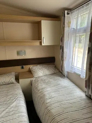 two beds in a small room with a window at Swift Serenity 50 in Ardentinny