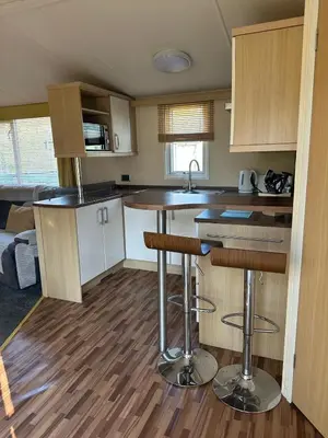 a kitchen with a counter and some bar stools at Swift Serenity 50 in Ardentinny