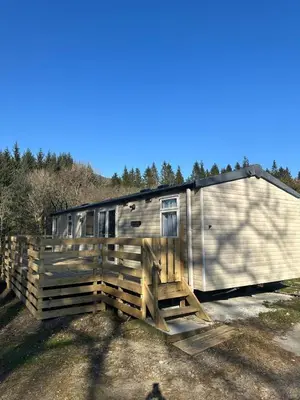 a metal trailer parked next to a wooden fence at Swift Serenity 50 in Ardentinny