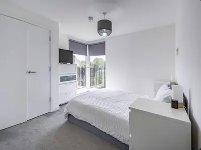 a white bedroom with a bed and a window at En-suite - Glasgow Riverside in Glasgow