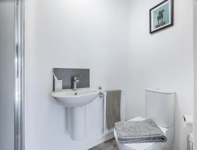 a white bathroom with a sink and a toilet at En-suite - Glasgow Riverside in Glasgow
