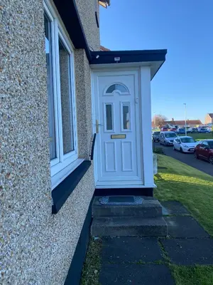a white door on the side of a house at Pure Home Oakley Park View by TBA in Dunfermline
