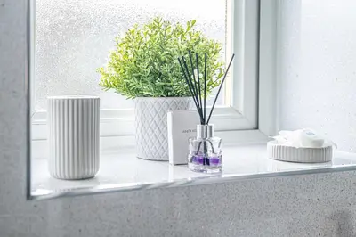 a window sill with two white vases and a plant at Pure Home Oakley Park View by TBA in Dunfermline