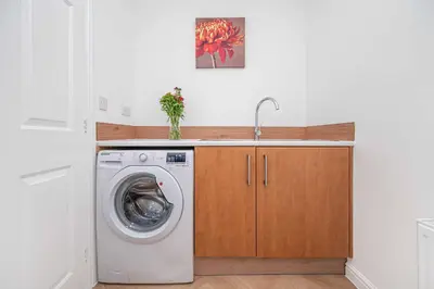 a washing machine in a kitchen with a sink at Super Prime Luxury 4 Bedroom Detached Home by TBA in Fife