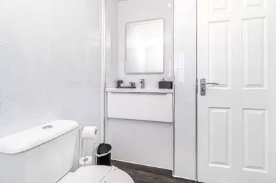 a white bathroom with a toilet and a sink at Super Prime Luxury 4 Bedroom Detached Home by TBA in Fife