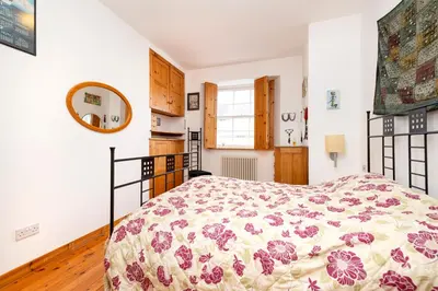 a bedroom with a bed with a floral bedspread at Edinburgh New Town Deluxe Apartment with Terrace in Edinburgh
