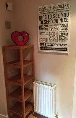 a room with a book shelf and a sign on the wall at Bright & Stylish West End Apartment in Edinburgh