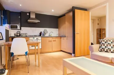 a kitchen and living room with a couch and a table at Bright & Stylish West End Apartment in Edinburgh