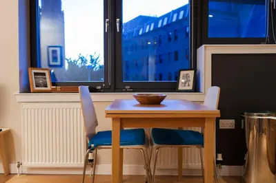 a table and two chairs with a table and a window at Bright & Stylish West End Apartment in Edinburgh