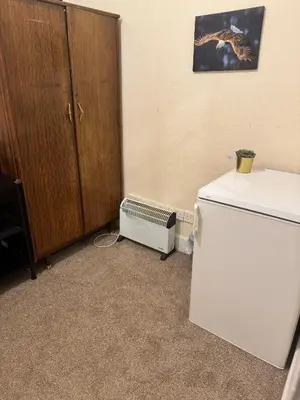 a room with a refrigerator and a cabinet at Haymarket Centro , Flat familiar quarto privativo banheiro compartilhado in Edinburgh