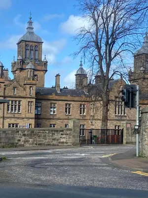 an old brick building with a tree in front of it at Haymarket Centro , Flat familiar quarto privativo banheiro compartilhado in Edinburgh