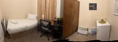 a bedroom with a bed and a desk with a chair at Haymarket Centro , Flat familiar quarto privativo banheiro compartilhado in Edinburgh