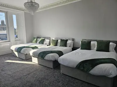 a room with three beds with green pillows at Central Hotel Edinburgh in Edinburgh