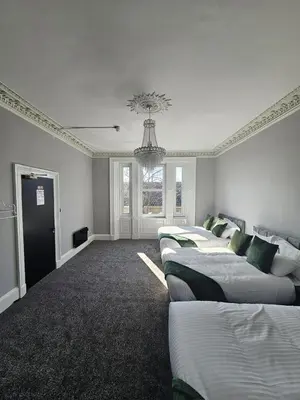a room with four beds and a chandelier at Central Hotel Edinburgh in Edinburgh