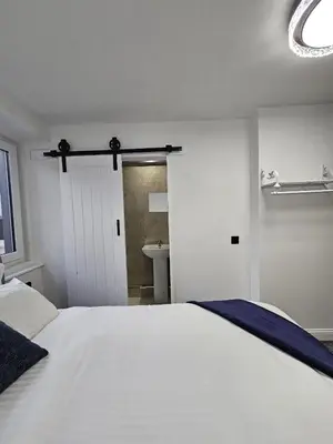 a bedroom with a large white bed and a bathroom at Central Hotel Edinburgh in Edinburgh
