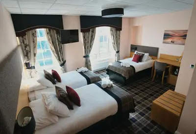 a hotel room with two beds and a desk at The Cornhill Inn in Falkirk