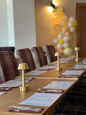 a long wooden table with chairs in a room at The Cornhill Inn in Falkirk