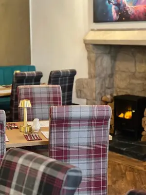 a room with chairs and a table with a fireplace at The Cornhill Inn in Falkirk