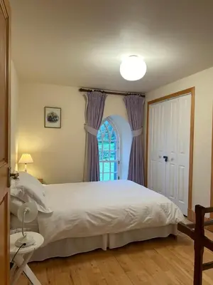 a bedroom with a large bed and a window at Leargy House in Isle of Jura