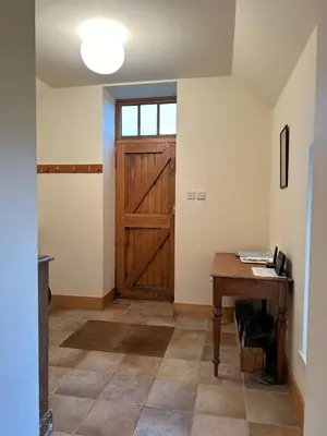 a room with a wooden door and a wooden table at Leargy House in Isle of Jura
