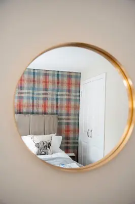 a mirror with a cat sitting on a bed at The Rise Retreat in Livingston