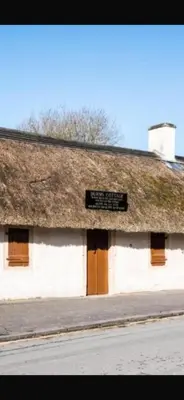 a building with a thatched roof with a sign on it at Saltayr in Ayr