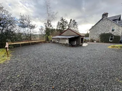 a large gravel parking lot in front of a house at Crannaig House in Aberfoyle