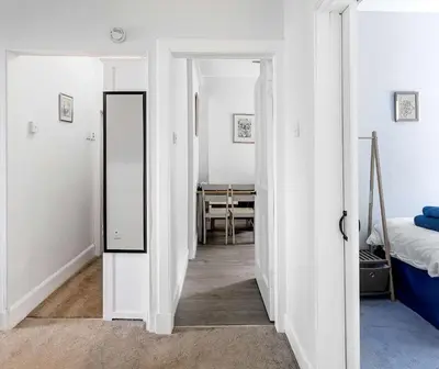 a hallway with a mirror and a bedroom at Coastal Charm in Kingarth