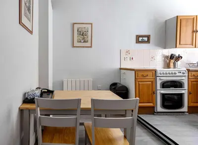 a kitchen with a wooden table and chairs at Coastal Charm in Kingarth