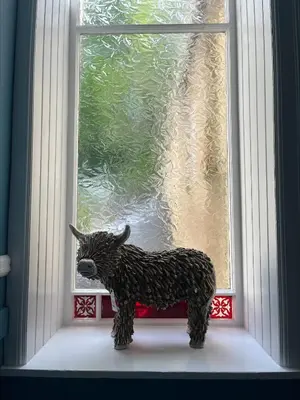 a toy cow standing in front of a window at Glenroy Guest House in Oban